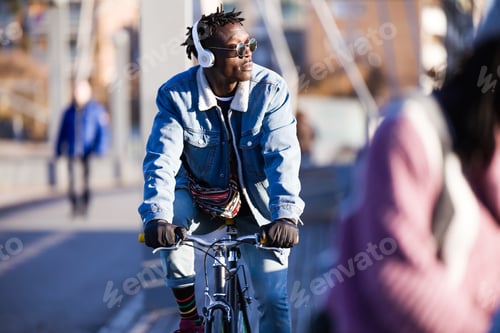 Vista previa: Joven apuesto que anda en bicicleta por la calle.