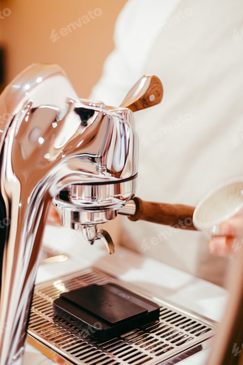 Preview: Shallow focus of a male hand preparing a cup for grounded coffee with a coffee machine