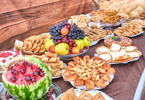 Preview: Traditional Siberian Tatar pastries and colorful fruit on table.