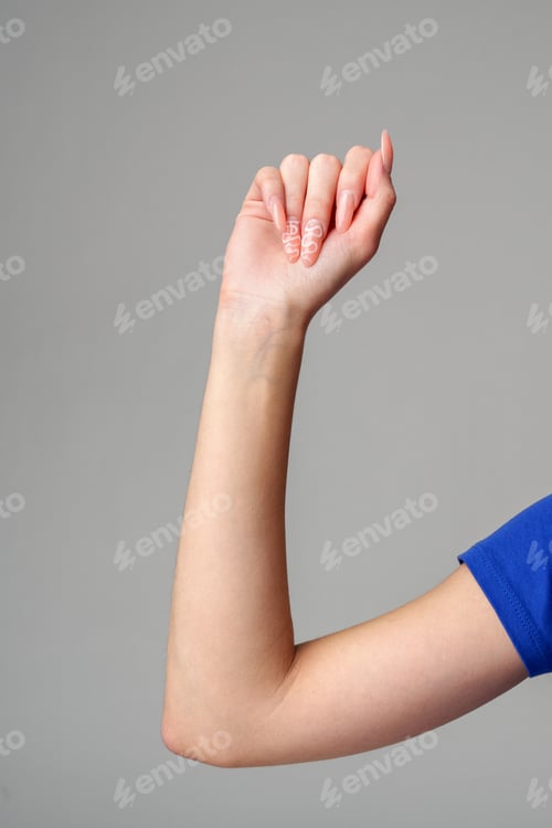 Preview: Female hand sign against gray background in studio