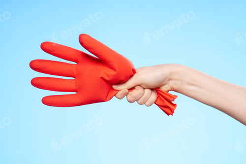 Preview: inflated rubber red glove in hand blue background and house cleaning