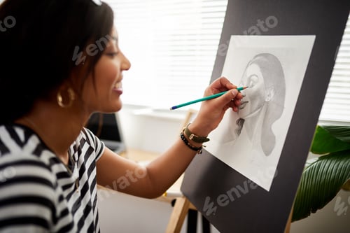 Preview: Shot of an attractive young artist drawing a portrait of a woman inside her studio