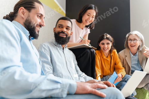Preview: Diverse team of professionals businesspeople collaborating on project using laptop and taking notes
