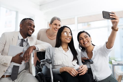 Preview: Cropped shot of a group of diverse businesspeople taking selfies while gathered in their office