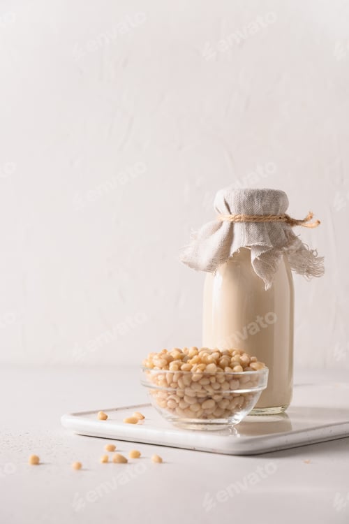 Preview: Cedar nut milk and nuts on white background. Alternative plant based milk.