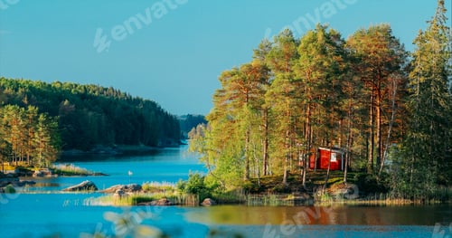 Preview: Sweden. Amazing Red Swedish Wooden Log Cabin House On Rocky Island Coast In Summer Sunny Evening