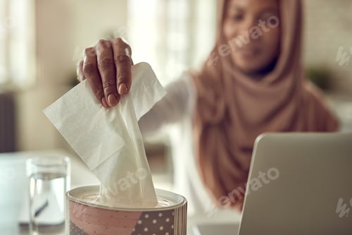 Preview: Close-up of black woman taking tissue from a box in the office.