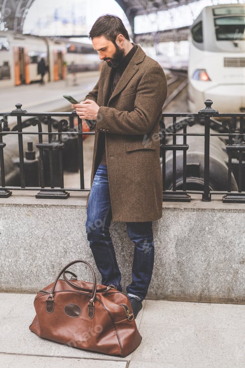 Preview: Man Awaiting Train with Bag at Urban Station