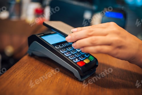 Preview: Woman making a contactless smartphone payment, close-up.