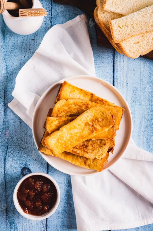 Preview: Traditional fried french toasts on white plate on table top and vertical view