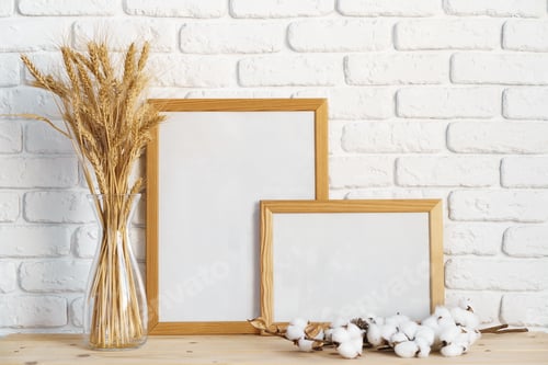 Preview: Vase with ears of wheat and photo frames against brick wall