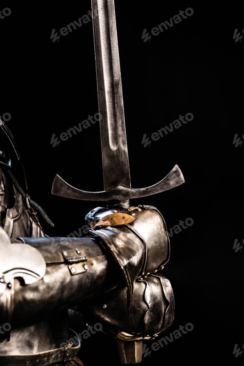 Preview: cropped view of knight in armor holding sword isolated on black