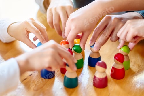 Preview: People choosing and picking up wooden figure from a group on the table