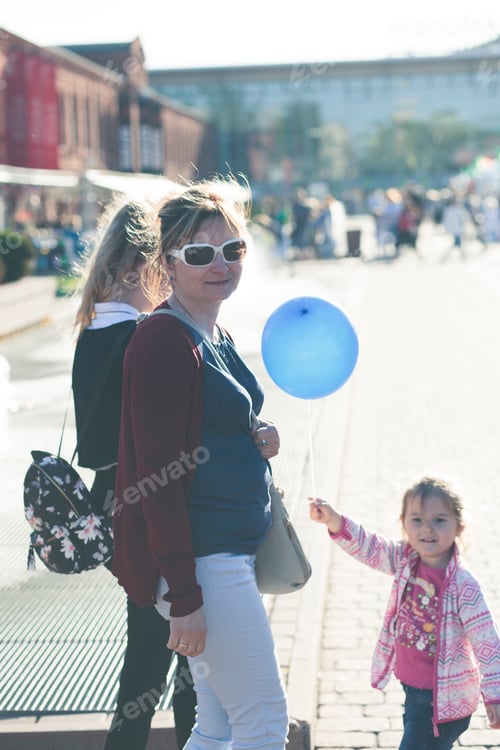 Preview: Mother walking with her daughters, spending time in center of city outdoors