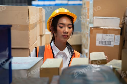 Preview: woman wearing visible vest hold clipboard in warehouse check and arrange box in the steel shelf
