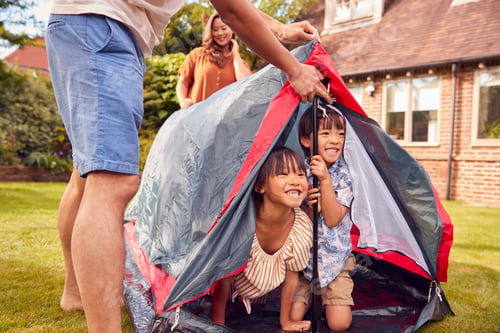 Preview: Asian Family In Garden At Home Putting Up Tent For Camping Trip Together