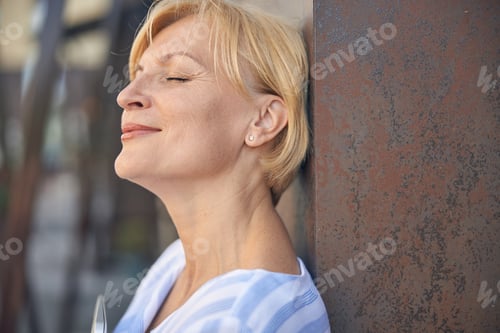Preview: Good-looking woman with a short haircut standing outside