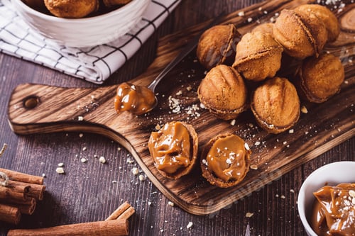 Preview: Fresh nut shaped cookies filled with boiled condensed milk on a board