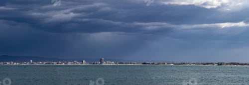 Preview: Panorama of the evening city located on a peninsula near the Black Sea covered with clouds