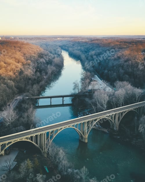 Preview: Long shot of a river lined with autumn trees and an arch bridge in the foreground