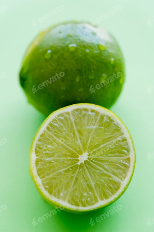 Preview: Close up view of juicy cut lime on green background