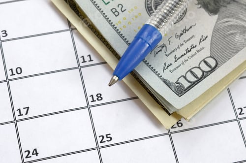 Preview: Pen and many hundred US dollar bills on calendar page close up