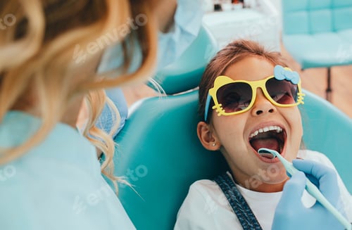 Preview: Cute little girl getting teeth exam at dental clinic