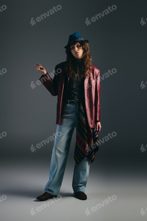 Preview: Handsome stylish man posing confidently in a trendy outfit against a dark backdrop