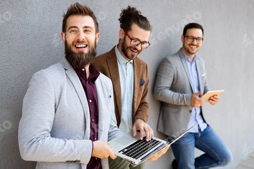 Preview: Cheerful happy businessmen using laptop at the meeting outdoor