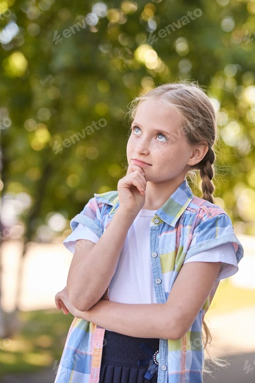 Preview: Thoughtful caucasian young girl in plaid shirt outdoors on sunny day