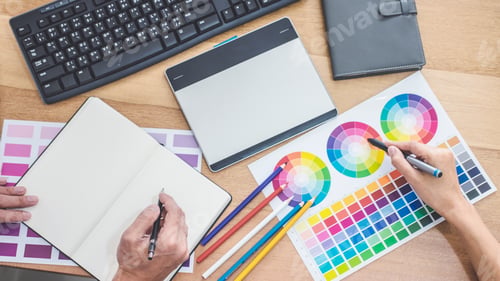 Preview: Two colleagues creative graphic designer working on color selection and drawing on graphics tablet