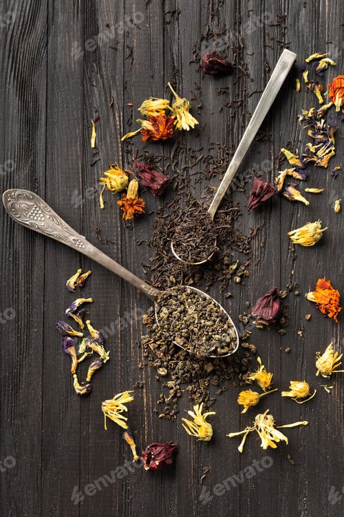 Preview: Dry green and black tea, flower tea on a dark background top view close-up.