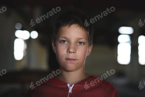 Preview: Sad and disappointed teenagers boy indoors in abandoned building, looking at camera.