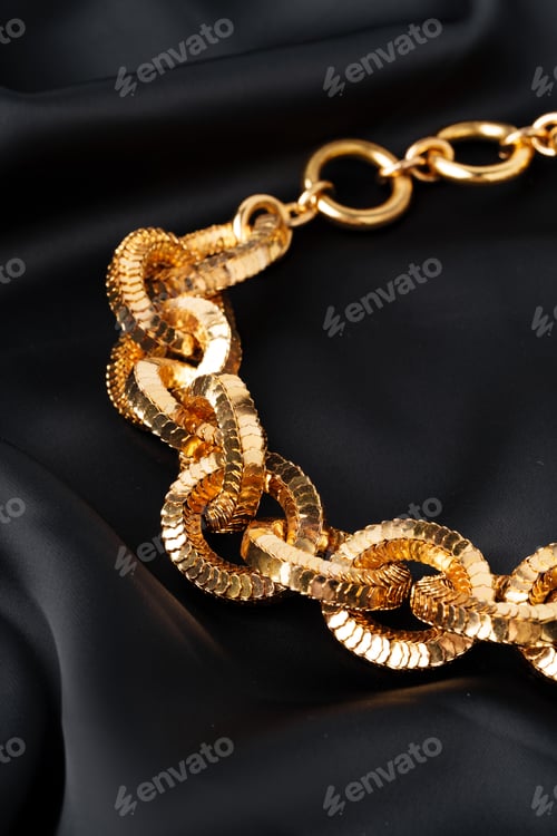 Preview: Gold chain on black silk fabric background