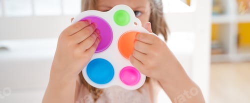Preview: Little girl,kid,child plays with colorful pop it children's room, bedroom.Funny trendy silicone anti
