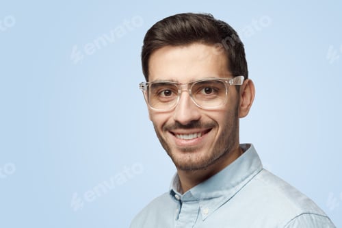 Preview: Young attractive European man with short haircut looks at camera with happy smile