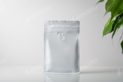 Preview: Mock-up of a coffee bag on a gray background with green leaves. Coffee gray bag with zipper.