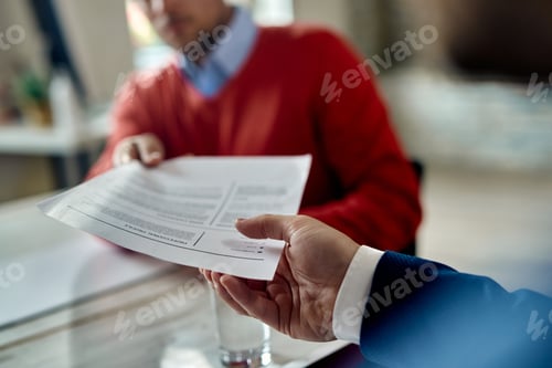 Preview: Close-up of job applicant giving his resume during job interview.