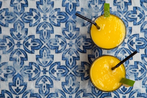 Preview: Fresh Tropical Fruit Smoothie Mango Juice on Blue Background. Copy Space. Top View.