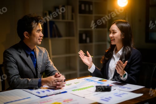 Preview: Business colleagues discussing financial data late in office