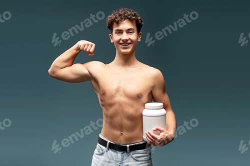 Preview: Strong, teenager boy with naked torso holding white bottle with mockup, showing biceps on hand