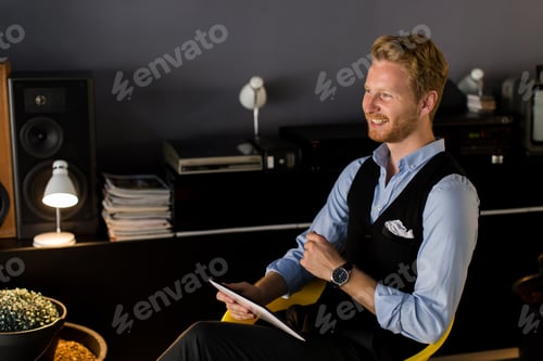 Preview: Young man with tablet in room