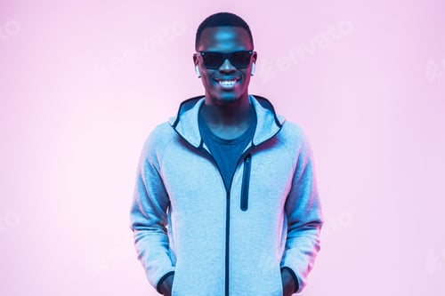 Preview: Young smiling handsome african man standing in gray hoodie and sunglasses