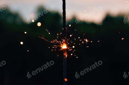 Preview: Sparkler firework burning with blurred background and copy space.