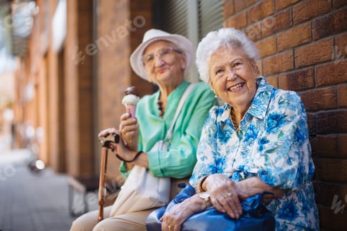 Preview: Portrait of two senior female friends in the city, eating ice cream on a hot summer day.