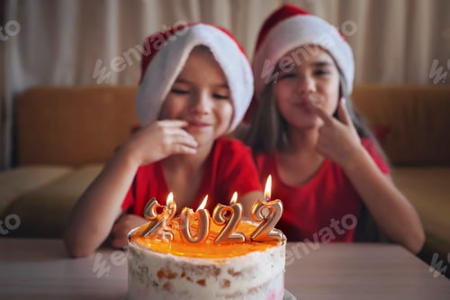 Preview: Happy sibling before Christmas cake with numbers, family New Year celebration, festive background