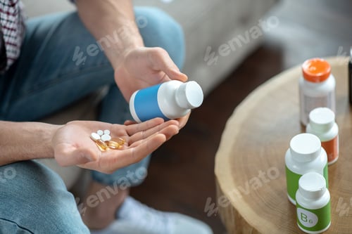 Preview: Close up picture of mans hands holding many pills