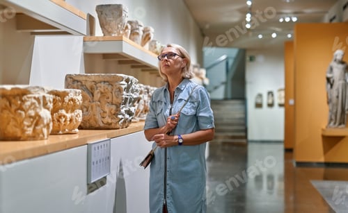Preview: Woman Visitor In Historical Museum Looking At Art Object