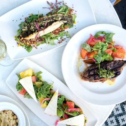 Preview: Top down view of summer dishes like watermelon salad, baked fish, and steak with side salad