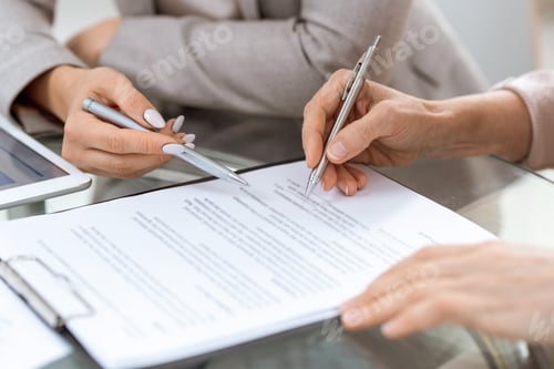 Preview: Human hands with pens over financial document in moment of putting signature